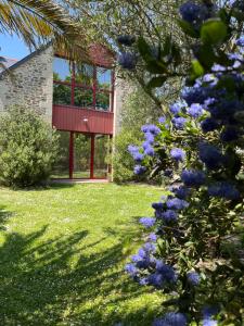 圣马洛Côt’et Calme的一座花园,在一座建筑前种有紫色花卉