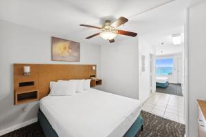 巴拿马城海滩Beach Tower Beachfront Hotel, a By The Sea Resort的一间卧室配有一张床和吊扇