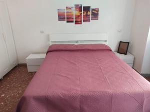 罗马Romamor 2的卧室内的一张带粉红色棉被的床