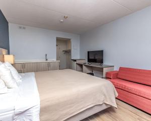 尼亚加拉瀑布Mamma's Inn的一间卧室配有一张大床和一张红色的沙发