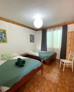 卡维塔Cabinas Cahuita的一间设有两张床和椅子的房间