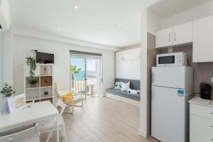 奎特里拉Stunning Studio with Beach Front- Astro Quarteira by Centralgarve的厨房以及带白色冰箱的客厅。