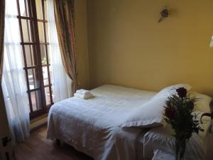 马丁内斯La Ribera Home & holidays的一间卧室配有一张带白色毯子的床和窗户。