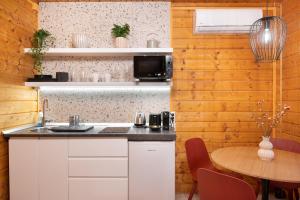 诺茨瓦约Chillout Apartman Noszvaj的厨房配有白色橱柜和木墙