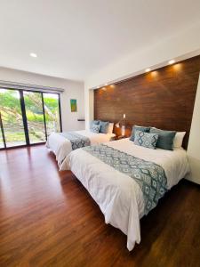 蒙泰韦尔德哥斯达黎加Burbi Lake Lodge Monteverde的配有2张床的酒店客房,铺有木地板