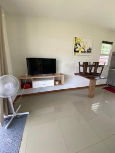 TaravaoJorsen House Tahiti 2 : bungalow confortable的客厅配有电视和桌子