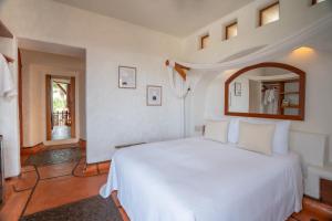 锡瓦塔塔内霍La Villa Luz (sólo adultos)的卧室配有白色的床和镜子