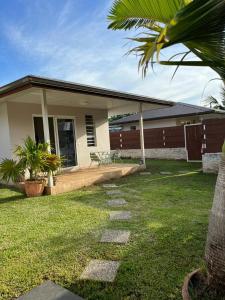 TaravaoJorsen House Tahiti 2 : bungalow confortable的一座带庭院和草地庭院的房子