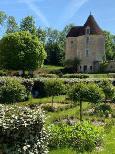 RémalardTour du manoir de Boiscorde的一座古老的石头房子,前面设有一个花园
