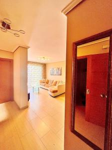 格拉纳迪利亚德亚沃纳3-bedrooms apartament Vista Roja的带沙发和镜子的客厅