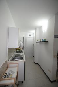 奇尼斯Casa Cinisi - Casa Vacanze的白色的厨房配有水槽和冰箱