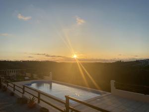 CadavalTerra Luso Proche De Montejunto的屋顶上的游泳池,享有日落美景
