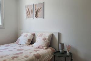 OsnyTulsa Home - Appartement 2 chambres, Charmant et moderne avec terrasse privée的一间卧室配有一张带两个枕头和一张桌子的床。