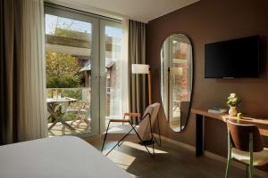 海德堡NH Collection Heidelberg的配有一张床、一张书桌和一扇窗户的酒店客房