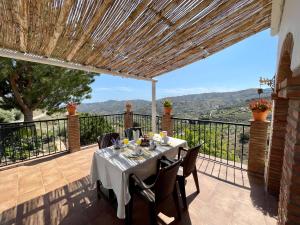弗里希利亚纳Villa en Frigiliana con Piscina y Jacuzzi的美景阳台的餐桌