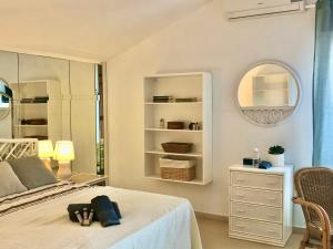 EsteponaMikaela Beach House Estepona Marbella Malaga的白色卧室配有床和镜子