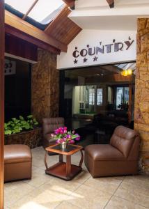特鲁希略Hotel Country Trujillo的大堂配有沙发和鲜花桌