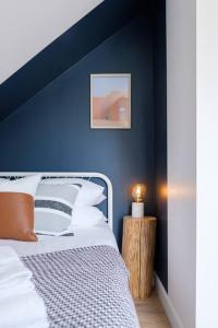 皮克顿Scandi Inspired 2 Bed Suite Sandbanks Pass Incl的一间卧室设有蓝色的墙壁和床