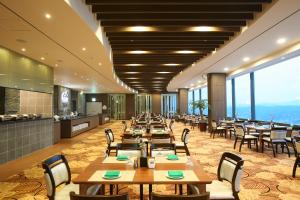 尤九Sun Valley Hotel的餐厅设有木桌和椅子以及大窗户。