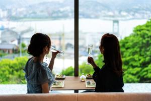 长崎长崎花园度假大酒店的坐在桌边喝酒的两位妇女