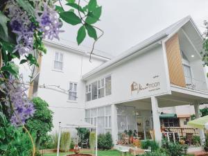 清迈Bloomin' Moon hostel & cafe, Chiang Mai Old Town的白色的建筑,标有餐厅标志