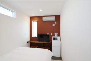 立山町Hotel Cradle Cabin Tateyama的小房间设有床和电视