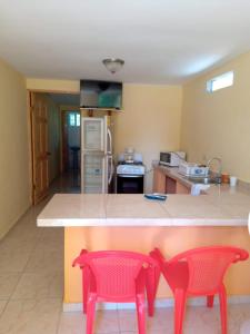 AntónCabañas El Valle的厨房在柜台上摆放着两把红色椅子