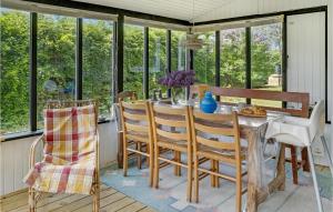 Bogø ByStunning Home In Bog By With Kitchen的一间带桌椅和窗户的用餐室