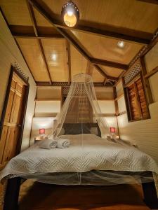 卡维塔Casa Siri de Cahuita的一间卧室配有一张带蚊帐的床