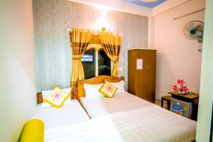 惹岛离山岛福绰酒店的一间卧室配有两张带黄色枕头的床