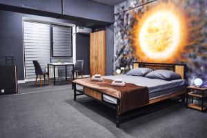 阿拉木图Gagarin Capsule Hotel的卧室配有一张大床,墙上挂有绘画作品