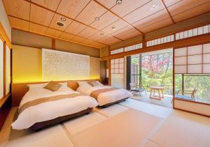 芦原市海亚旅馆的一间卧室设有两张床和大窗户