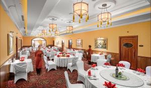 河内河内财神酒店的用餐室配有白色的桌子和白色的椅子