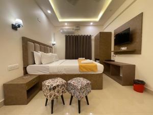 巴加Yellow Sky的一间卧室配有一张带两把椅子的床和一台电视。