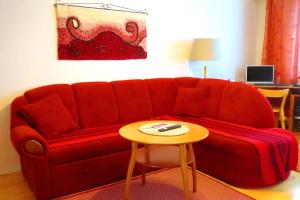 努尔梅斯Retrohenkinen kaksio Nurmeksen keskustassa.的客厅里一张红色的沙发,配有桌子