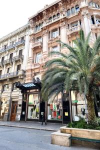 巴里斯帕拉诺豪华套房住宿加早餐旅馆的一座大建筑,前面有棕榈树