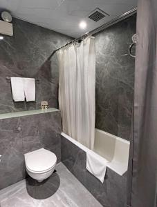 香港Hennessy Hotel的浴室配有卫生间、淋浴和浴缸。
