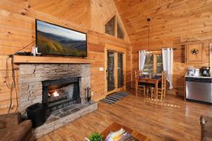鸽子谷A Mountain Surprise的客厅设有壁炉和平面电视。