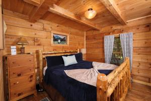 鸽子谷A Mountain Surprise的小木屋内一间卧室,配有一张床