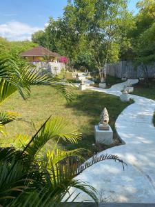 吉利美诺Villa Samalas Resort and Restaurant的一座花园,在路上设有石雕