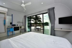 甲米镇甲米船舶泻湖度假村的卧室配有一张白色大床和滑动玻璃门