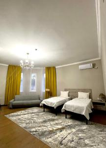 奇姆肯特MINI HOTEL COMFORT的一间带两张床和一张沙发的客厅