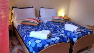 拉奎拉B&B L'Aquila的两张单人床、枕头和毛巾
