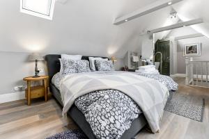 伦敦Woodbridge House Apartment的一间卧室配有一张带黑白色棉被的床