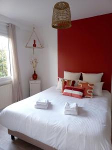 Montjean-sur-LoireLe Clos Beauséjour的卧室配有一张白色大床和红色墙壁