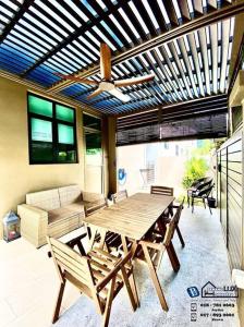 峇都丁宜Batu Ferringhi Luxurious Modern Designed 5BR House的庭院配有木桌和椅子