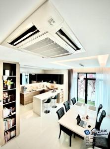 峇都丁宜Batu Ferringhi Luxurious Modern Designed 5BR House的一间带桌椅的客厅和一间厨房