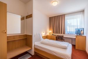 格拉茨克恩布阿姆酒店的配有一张床和一张书桌的酒店客房