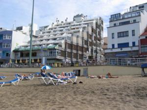 大加那利岛拉斯帕尔马斯Vacacional Playa Las Canteras的一群人躺在沙滩上的椅子上