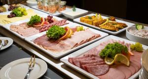 不莱梅PLAZA Premium Columbus Bremen的自助餐,包括多种不同的肉类和蔬菜